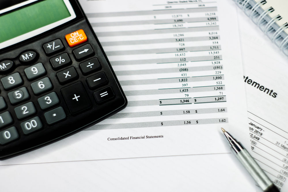 Calculator on financial documents illustrating financing options for athletic surfacing projects.