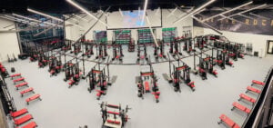 Weight room featuring advanced fitness equipment and impact-resistant flooring, designed for optimal performance and safety in athletic training environments.
